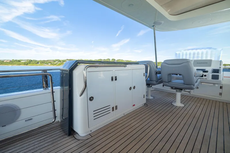 Slide: The Image of Luxurious 2019 Sirena 64 yacht deck with seating and navigation equipment, overlooking serene waters. - 81