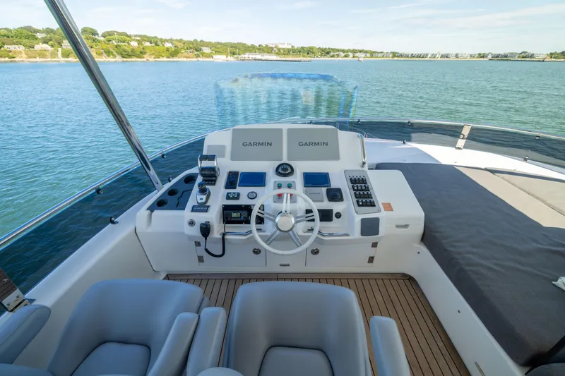 Slide: The Image of Helm of 2019 Sirena 64 yacht with Garmin navigation, overlooking serene waters. - 82
