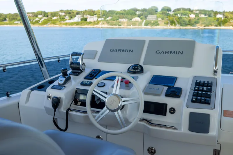 Slide: The Image of Helm of 2019 Sirena 64 yacht with Garmin navigation systems, overlooking serene waters. - 86