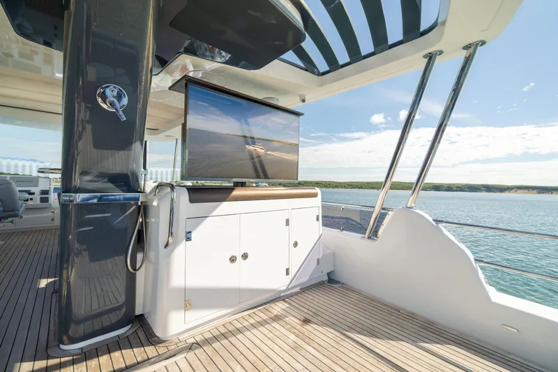 Slide: The Image of Luxurious 2019 Sirena 64 yacht deck with TV, overlooking serene ocean view. - 92