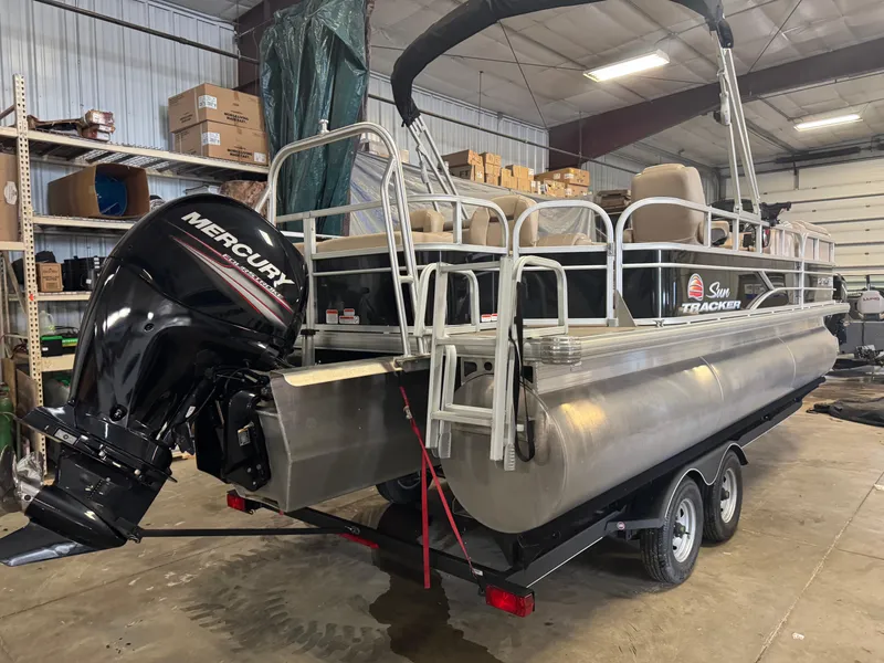 Slide: The Image of 2019 Sun Tracker SportFish 22 XP3 pontoon boat with Mercury outboard motor in a storage facility. - 3