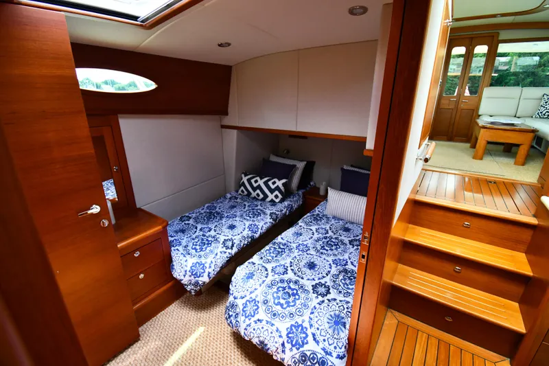 Slide: The Image of 2020 Palm Beach Motor Yachts PB52 cabin with twin beds and elegant wood finish. - 47
