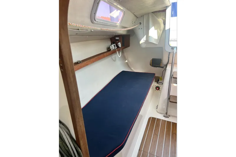 Slide: The Image of 2005 J Boats J/100 cabin interior with blue cushioned berth and wooden flooring. - 18