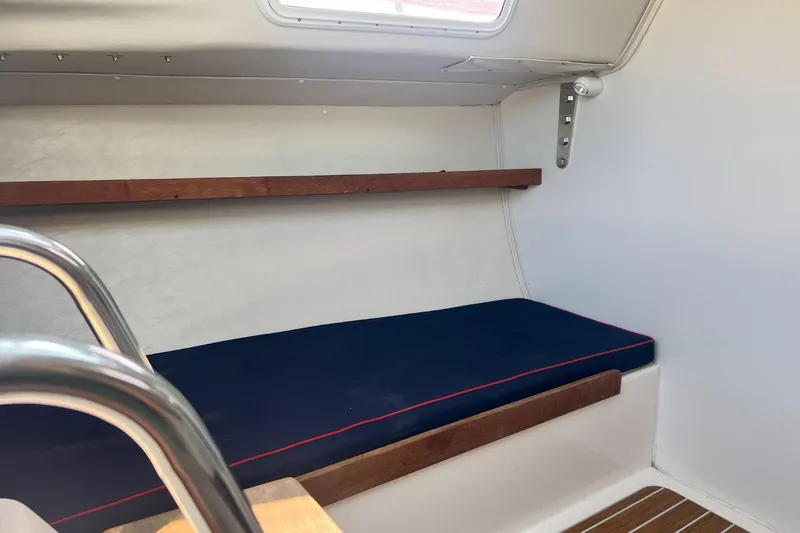 Slide: The Image of Interior of 2005 J Boats J/100 sailboat with blue cushioned seating and wooden accents. - 21