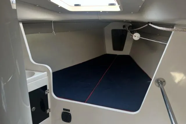 Slide: The Image of 2005 J Boats J/100 interior cabin with blue bedding and overhead hatch. - 22