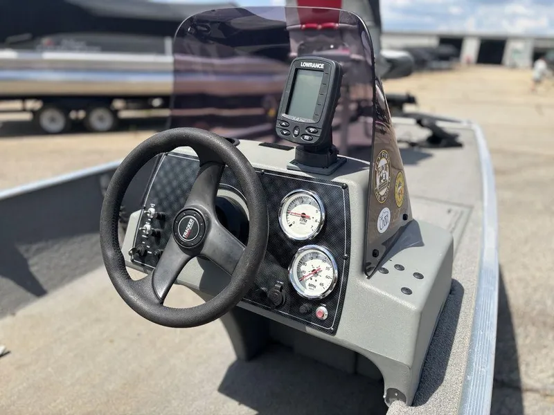 Slide: The Image of 2013 Tracker Pro 160 boat dashboard with steering wheel and gauges. - 12