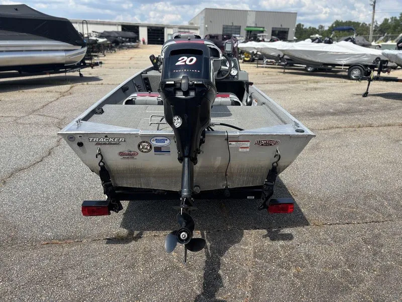 Slide: The Image of 2013 Tracker Pro 160 boat with a 20 horsepower outboard motor, parked outdoors. - 3