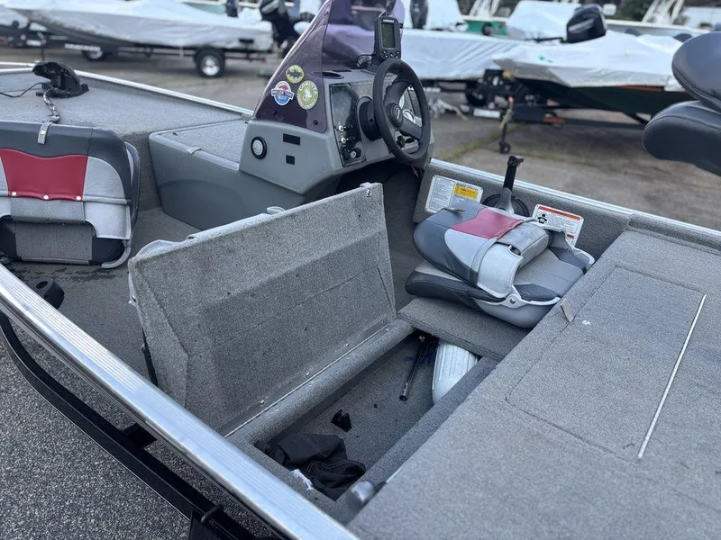 Slide: The Image of 2013 Tracker Pro 160 boat interior with open storage compartment and steering console. - 9