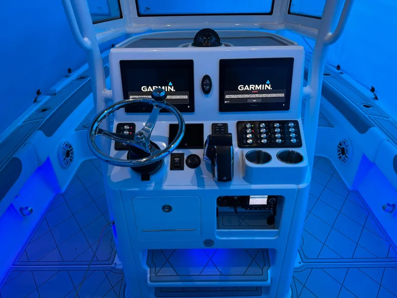 Slide: The Image of 2024 Caymas 28 HB boat dashboard with Garmin displays and illuminated controls. - 10