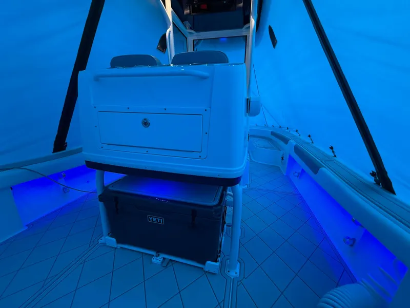Slide: The Image of 2024 Caymas 28 HB boat interior with blue LED lighting and Yeti cooler. - 14