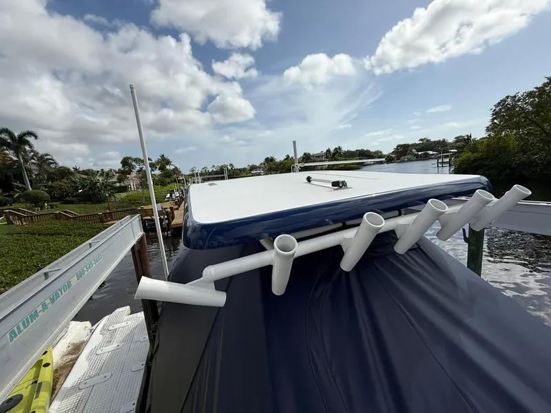 Slide: The Image of 2024 Caymas 28 HB boat with rod holders, docked by a scenic waterfront. - 15