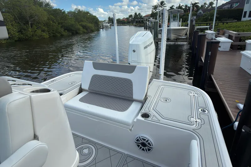 Slide: The Image of 2024 Caymas 28 HB boat with seating and Mercury outboard engine on a calm waterway. - 21