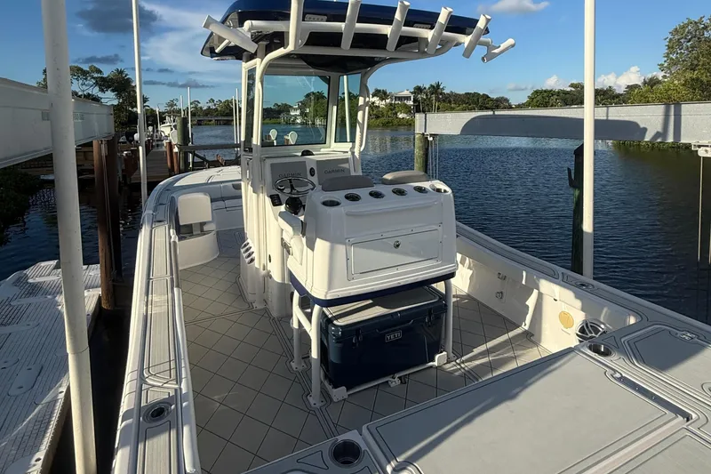 Slide: The Image of 2024 Caymas 28 HB boat docked, featuring a spacious deck and modern console. - 22