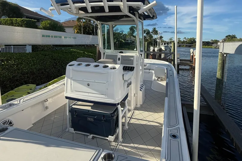 Slide: The Image of 2024 Caymas 28 HB boat docked, featuring a spacious deck and modern console. - 23