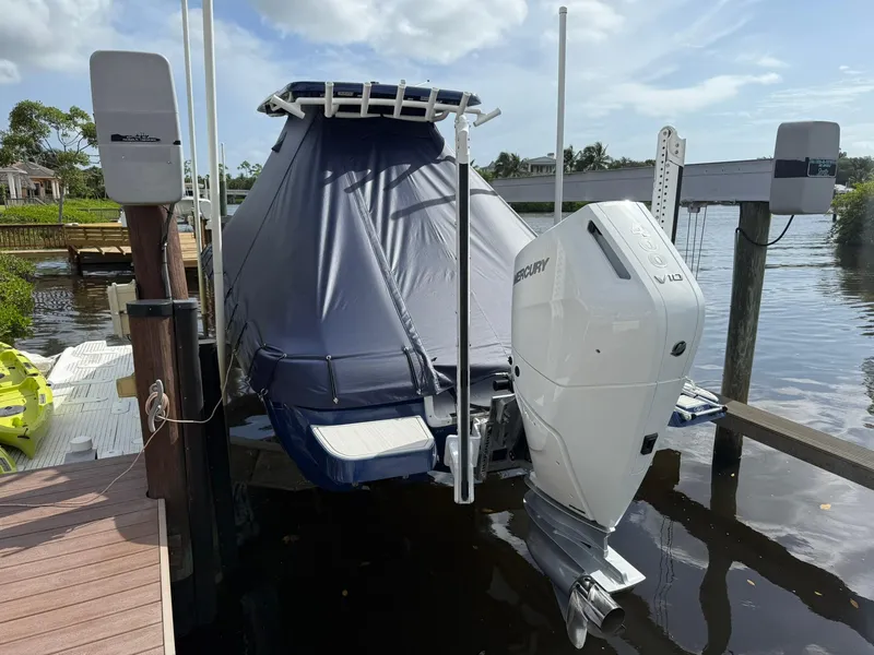 Slide: The Image of 2024 Caymas 28 HB boat with Mercury V10 engine, docked and covered, on a sunny day. - 4