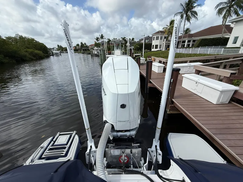 Slide: The Image of 2024 Caymas 28 HB boat docked, featuring dual Power-Pole anchors and a powerful outboard motor. - 5