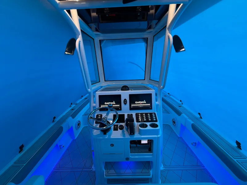 Slide: The Image of 2024 Caymas 28 HB boat cockpit with Garmin displays and blue ambient lighting. - 8
