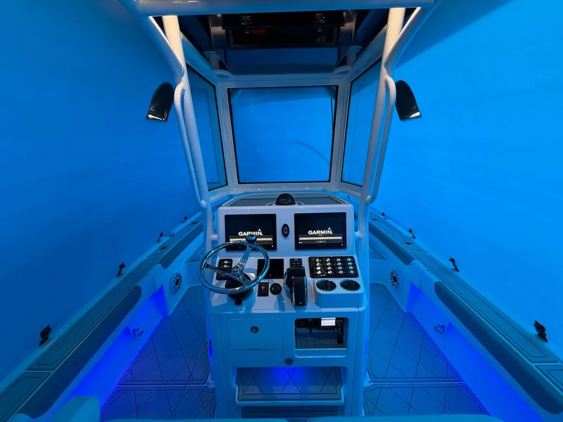 Slide: The Image of 2024 Caymas 28 HB boat cockpit with Garmin navigation, illuminated in blue lighting. - 9