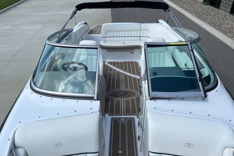 Slide: The Image of 2006 Cobalt 240 boat with white seating and sleek design, docked on a paved surface. - 15