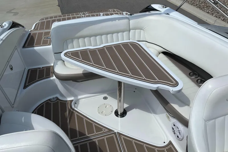 Slide: The Image of 2006 Cobalt 240 boat interior with white seating and brown table. - 16