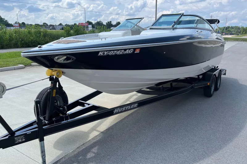 Slide: The Image of 2006 Cobalt 240 boat on trailer, parked outdoors under a cloudy sky. - 5