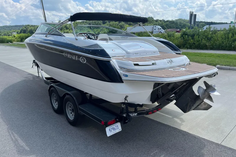 Slide: The Image of 2006 Cobalt 240 boat on trailer, parked outdoors under a cloudy sky. - 7