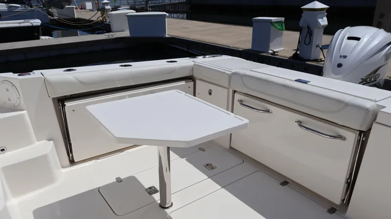 Slide: The Image of 2023 Pursuit OS 355 Offshore boat interior with seating and table setup. - 11
