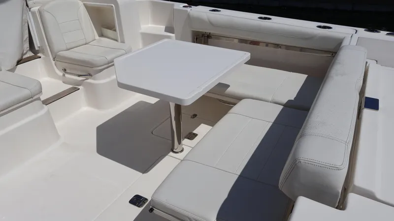 Slide: The Image of 2023 Pursuit OS 355 Offshore boat interior with white seating and table. - 15