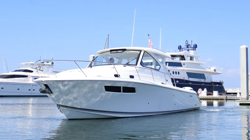 Slide: The Image of 2023 Pursuit OS 355 Offshore boat docked in marina, clear blue sky background. - 2