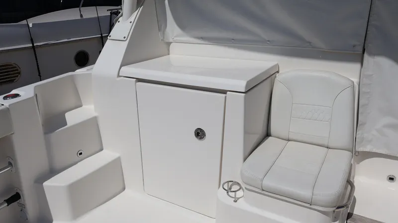 Slide: The Image of 2023 Pursuit OS 355 Offshore boat interior with white seating and storage compartment. - 20
