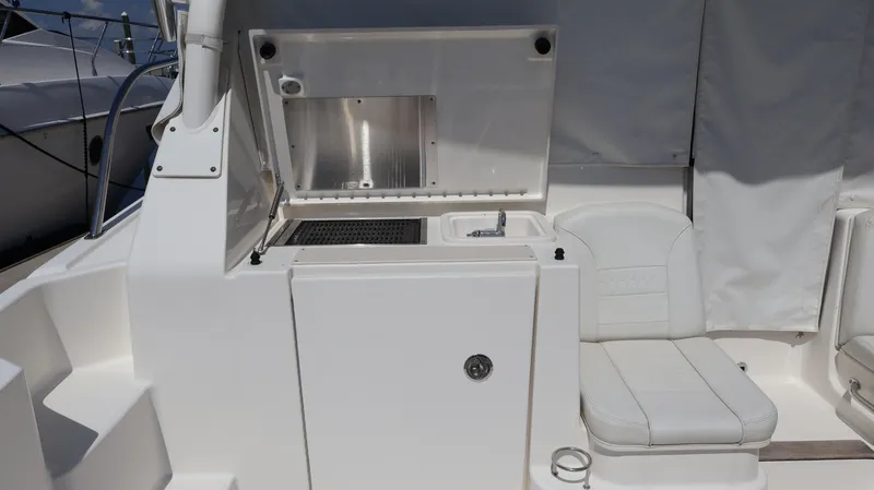 Slide: The Image of 2023 Pursuit OS 355 Offshore boat interior with seating and kitchenette area. - 21