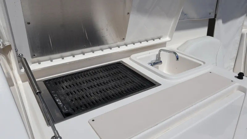 Slide: The Image of Outdoor kitchen setup on 2023 Pursuit OS 355 Offshore boat, featuring grill and sink. - 23