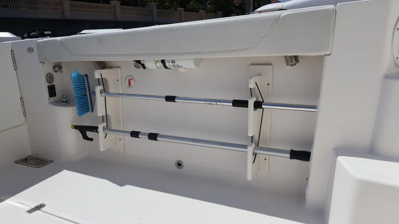 Slide: The Image of 2023 Pursuit OS 355 Offshore boat interior storage compartment with cleaning tools. - 30