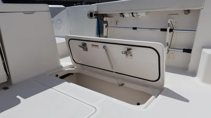 Slide: The Image of 2023 Pursuit OS 355 Offshore boat storage compartment with open hatch and hydraulic support. - 31