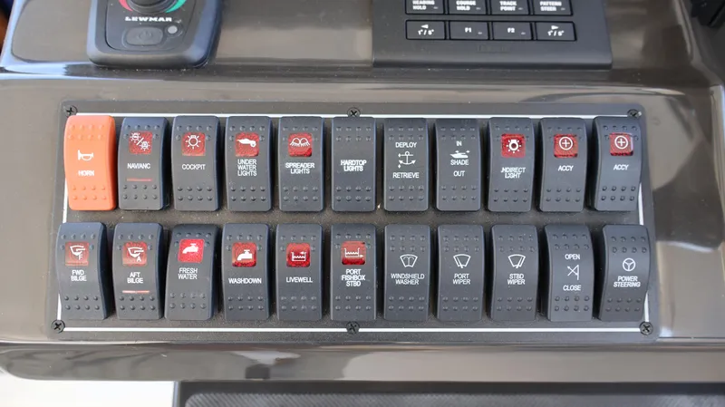 Slide: The Image of Control panel of 2023 Pursuit OS 355 Offshore boat with labeled switches. - 39