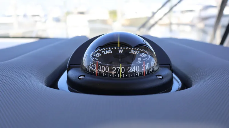 Slide: The Image of Compass on 2023 Pursuit OS 355 Offshore boat dashboard, close-up view. - 44