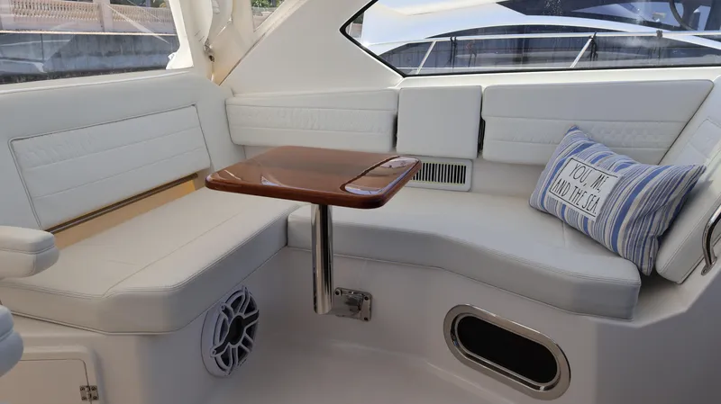 Slide: The Image of Luxurious interior of 2023 Pursuit OS 355 Offshore boat with cushioned seating and wooden table. - 45
