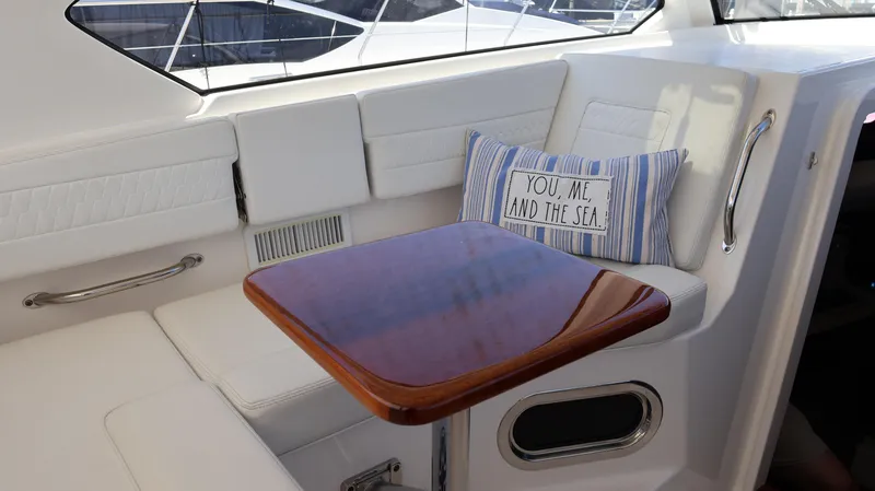 Slide: The Image of 2023 Pursuit OS 355 Offshore interior with cushioned seating and decorative pillow. - 46