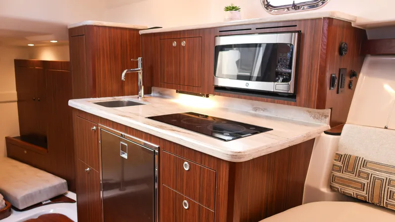 Slide: The Image of 2023 Pursuit OS 355 Offshore yacht kitchen with modern appliances and wood cabinetry. - 48