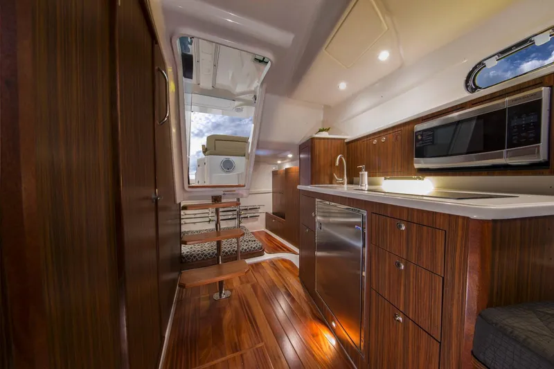 Slide: The Image of Manufacturer Provided Image: 2023 Pursuit OS 355 Offshore yacht interior with modern kitchen and wood finishes. - 53