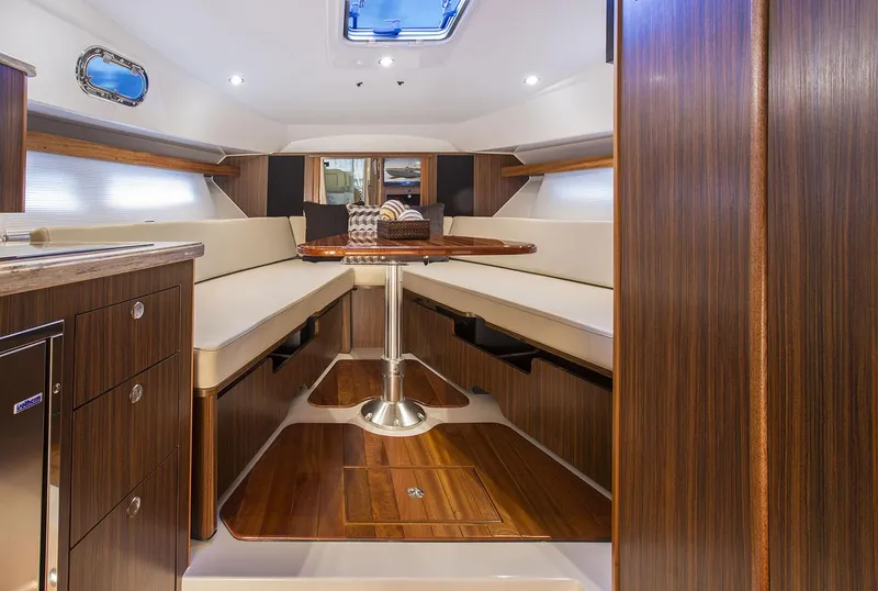 Slide: The Image of Manufacturer Provided Image: 2023 Pursuit OS 355 Offshore cabin interior with wood finish and seating area. - 57