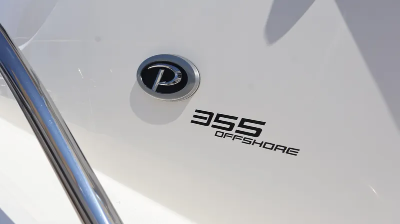 Slide: The Image of 2023 Pursuit OS 355 Offshore boat emblem and model name on hull. - 6
