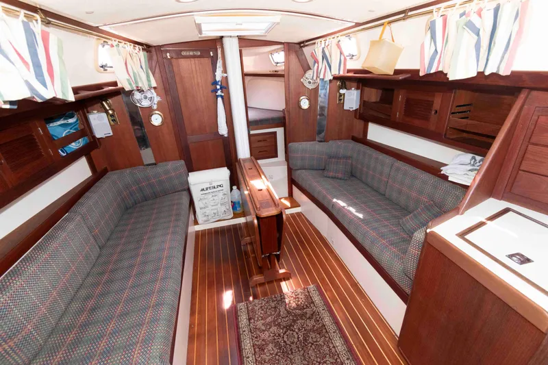 Slide: The Image of Interior of a 1994 Tartan 31 sailboat with wood paneling and plaid seating. - 11
