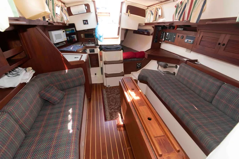 Slide: The Image of Interior of a 1994 Tartan 31 sailboat with wood finish and cozy seating. - 12