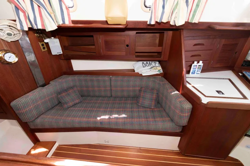 Slide: The Image of Cozy interior of a 1994 Tartan 31 sailboat with plaid sofa and wooden cabinetry. - 13