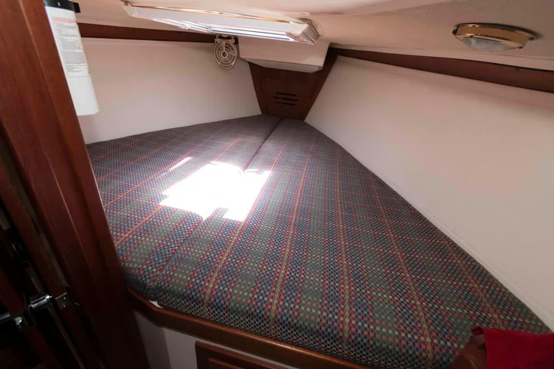 Slide: The Image of Cozy cabin interior of 1994 Tartan 31 sailboat with patterned bedding. - 17