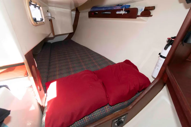 Slide: The Image of Cozy cabin interior of 1994 Tartan 31 sailboat with red pillows and fire extinguisher. - 18