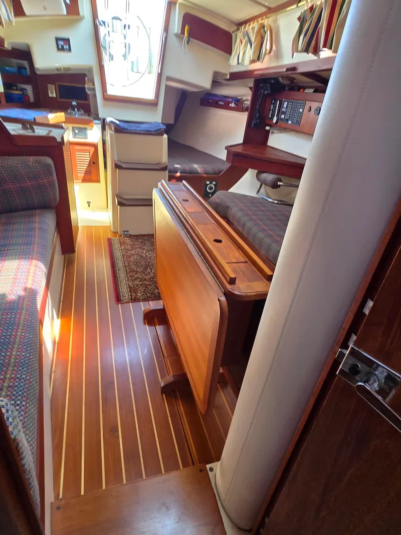 Slide: The Image of Interior of a 1994 Tartan 31 sailboat, featuring wood flooring and cozy seating. - 20
