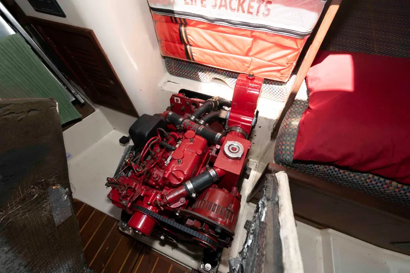 Slide: The Image of Engine compartment of a 1994 Tartan 31 sailboat, featuring a red engine and life jackets. - 23
