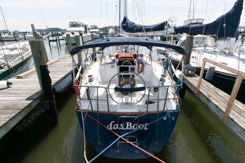 Slide: The Image of 1994 Tartan 31 sailboat docked at marina, rear view with blue canopy. - 3